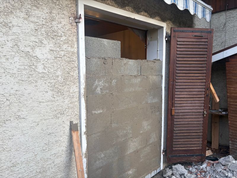 Montage de blocs agglomérés pour condamner une habitation en attente de démolition